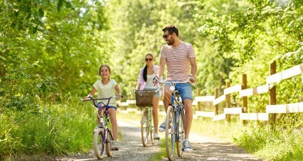 two people bicycling with young girl