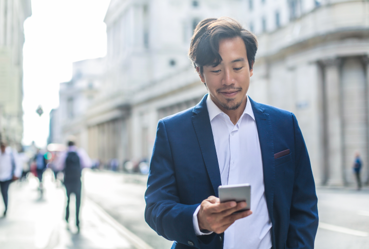 Photo of a man with a suit looking at his phone