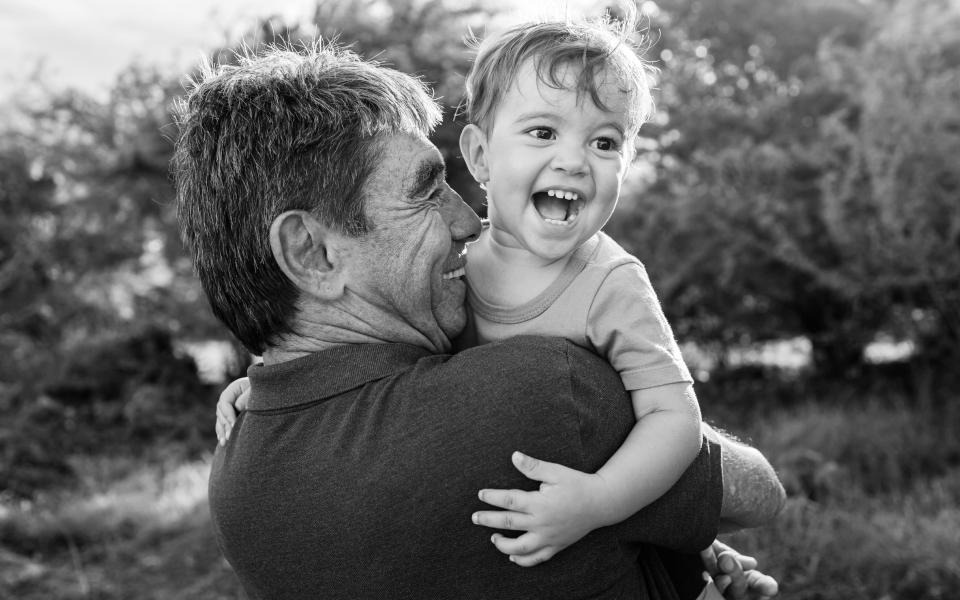 Man holding toddler and smiling