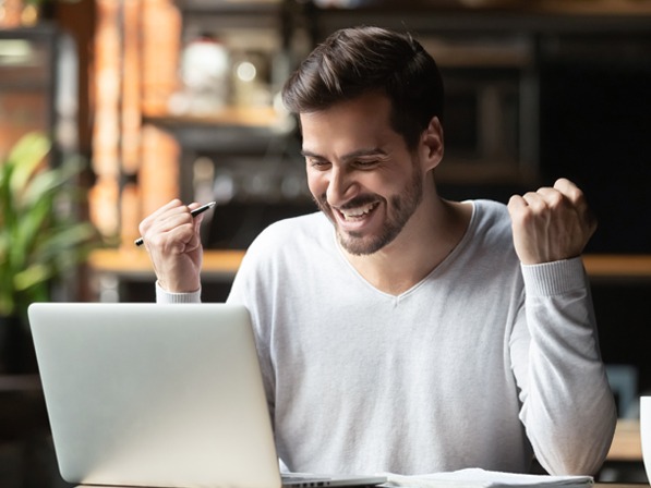 Man smiling at his computer.