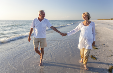 Older couple walking along a beachfront