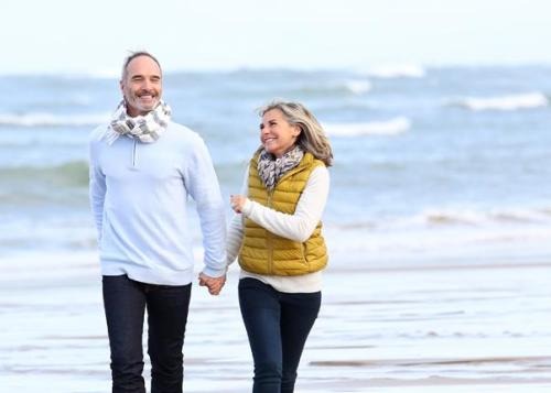 Beach - Retirees, couple walking on the beach holding hands