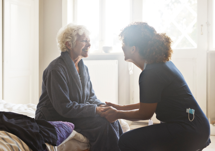 medical professional holding a patients hands and both are smiling