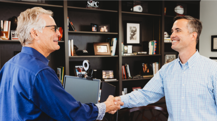 two men in an office shaking hands