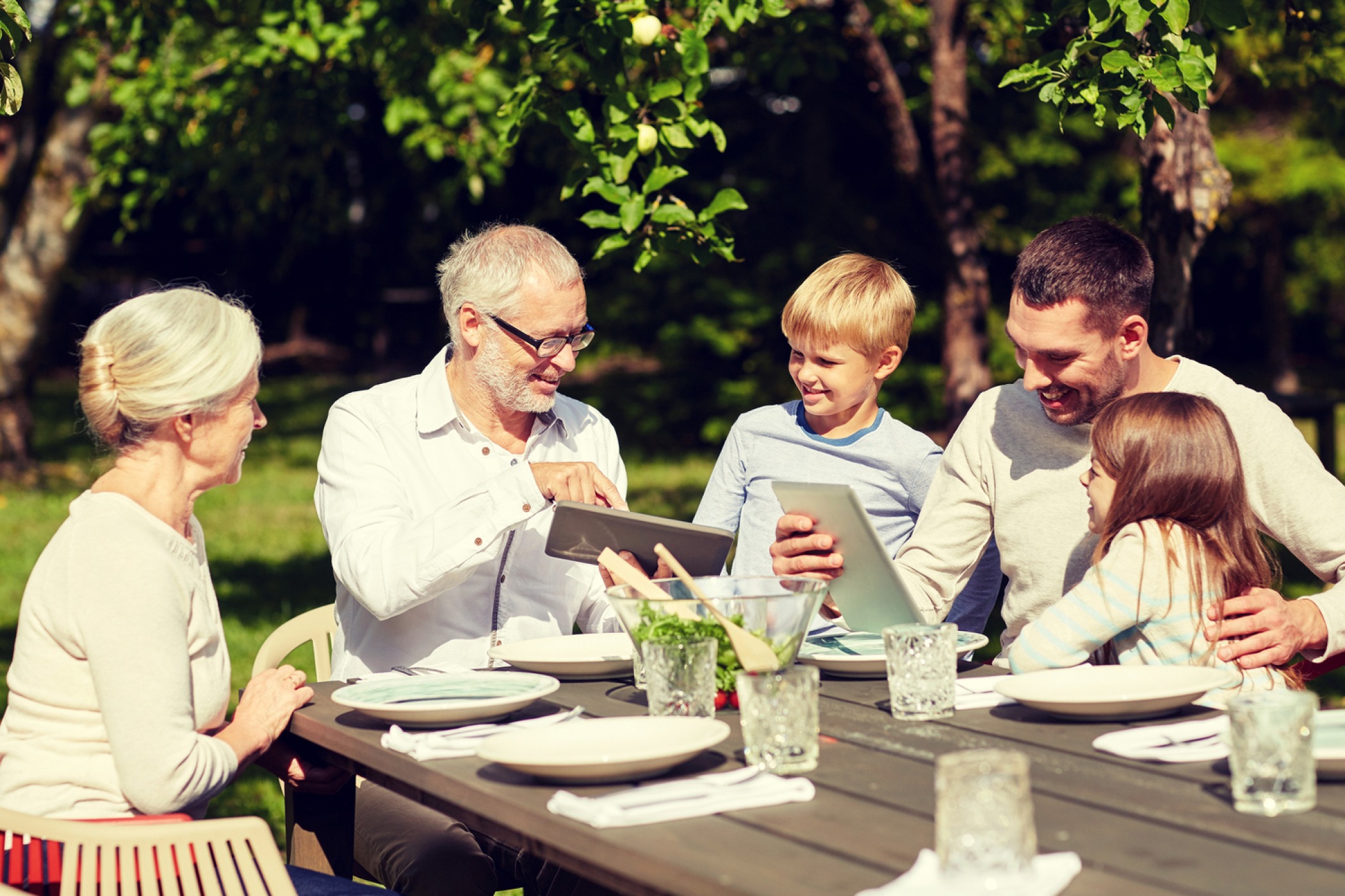 Multigenerational family sitting at a table looking at computers