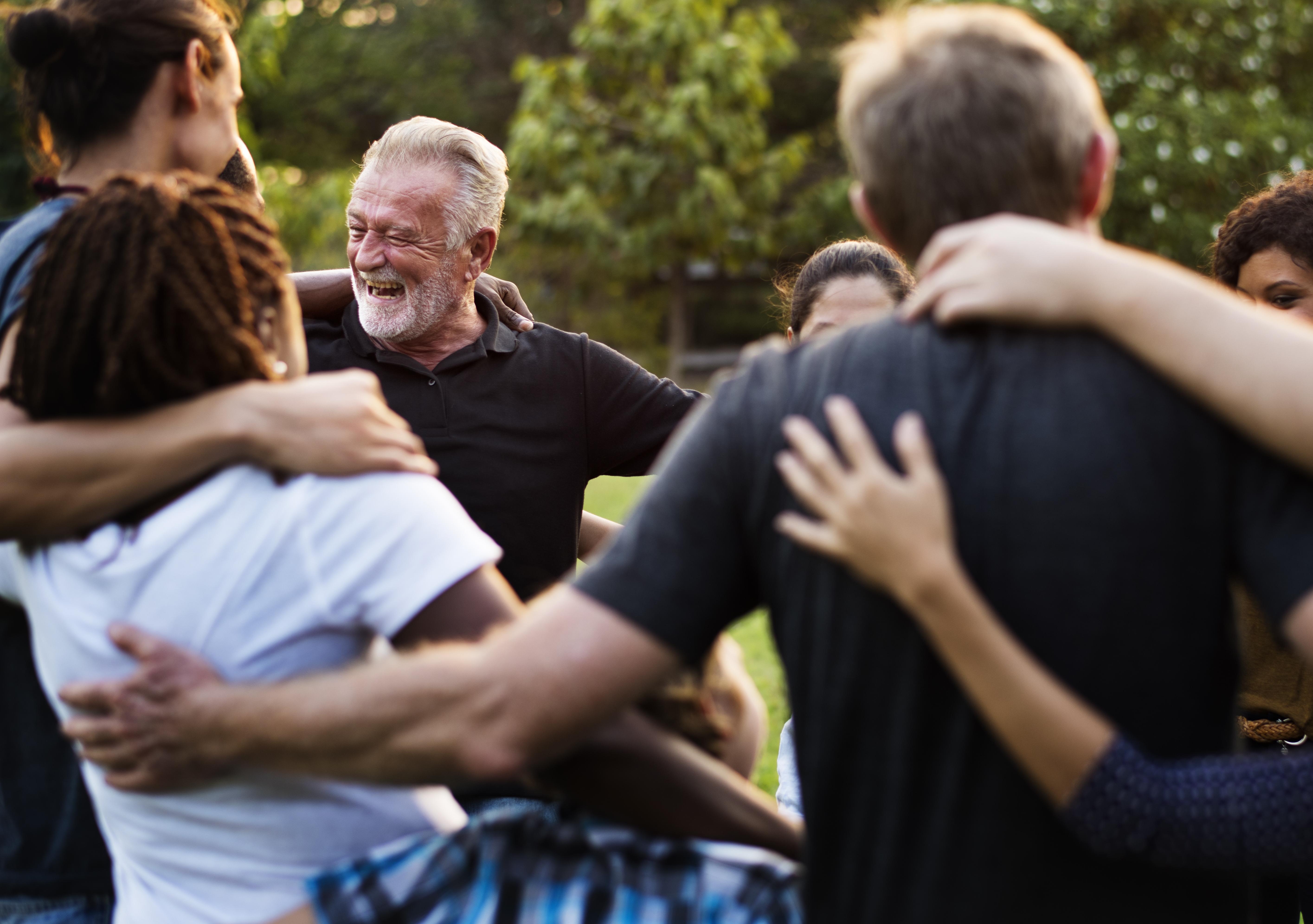 Group of people hugging in a circle outside