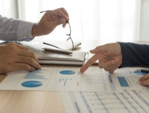 Two people reviewing financial document across from eachother on a desk