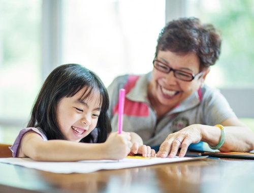A little girl and her grandmother engage in a project together