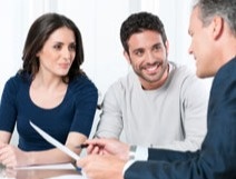 Man and woman smiling at another man talking