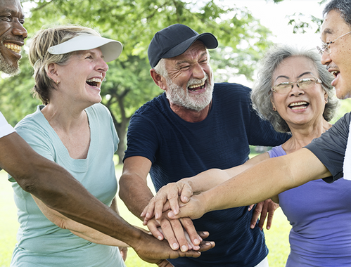 Group of elderly friends doing a team huddle celebration