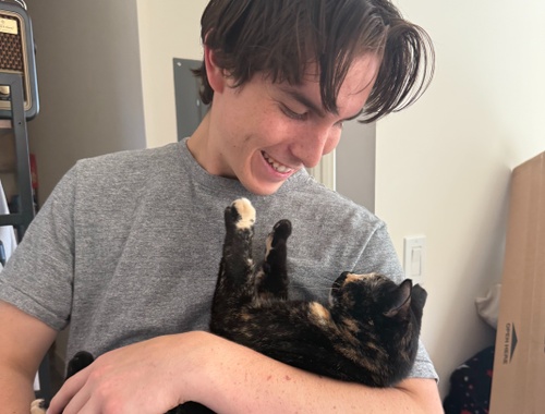 Noah enjoying time with his cat Cinnamon