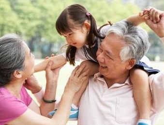Grandparents giving granddaughter ride on shoulders