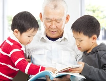 grandfater reading to his two grandchildren