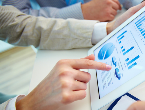 person holding a tablet and looking at graphs