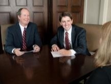 Peter Ruth and Ken Brown from the Brown Ruth Advisors team smiling while sitting at a table