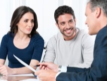 Man and woman smiling at another man talking