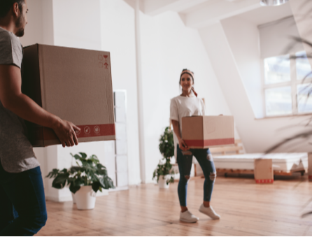 couple moving into a new apartment and carrying boxes