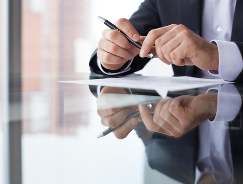 Businessman holding a pen over a document