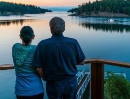 Two people out on a dock at dusk.