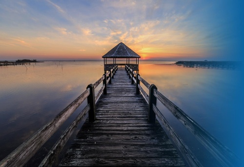 Oceanside peer into a hut at sunset