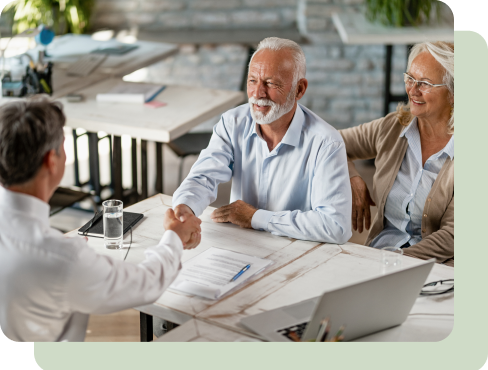 Older couple shaking hands with financial advisor