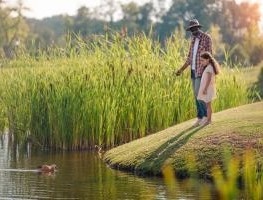 Man by river with grandson.