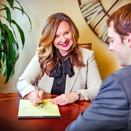 Klaudia Conradt smiling while writing on a notepad